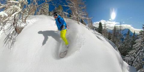 SELFIE, LENS FLARE: Extreme winter athlete goes tree snowboarding on a sunny day