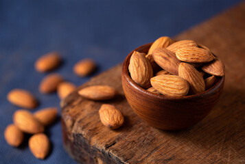 Close-up of raw almonds with a blue background with copy space