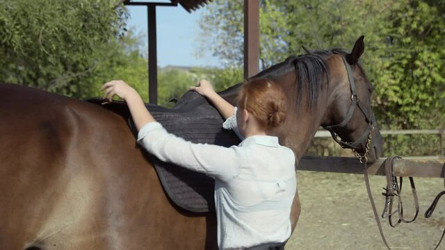 Young female rider put Bareback Riding Pad on her horse