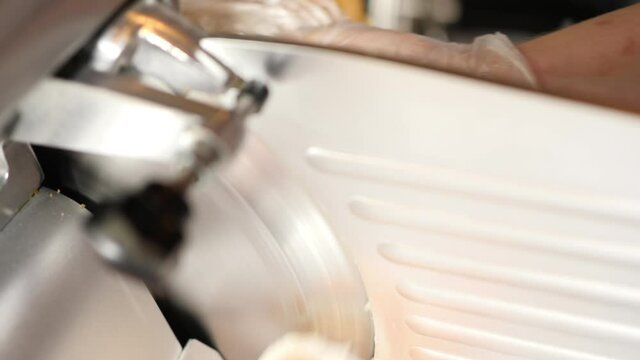 Meat slicing machine cuts finished processed meat products. Electric food slicer. 4K