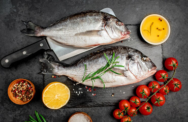 Raw dorado fish with spices on a stone background 