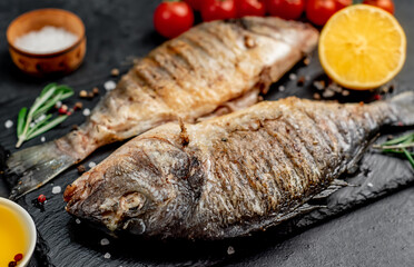 grilled dorado fish with spices on a stone background