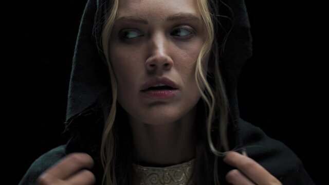Beautiful young woman with black hood on her head is looking around, 4k