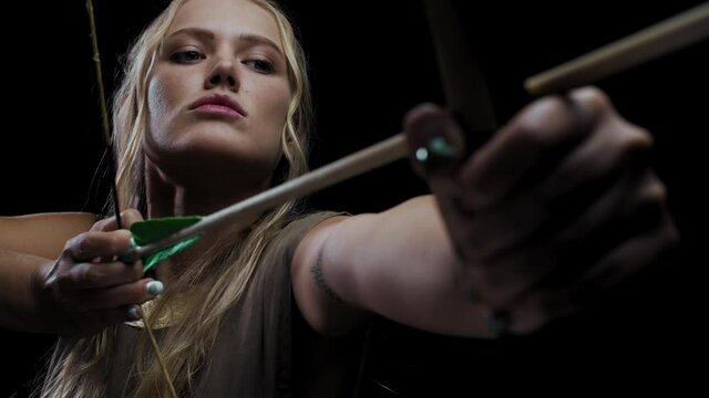 Blonde female archer is aiming her bow during battle, 4k