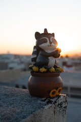 Raccoon statue with sunrise or sunset at golden hour