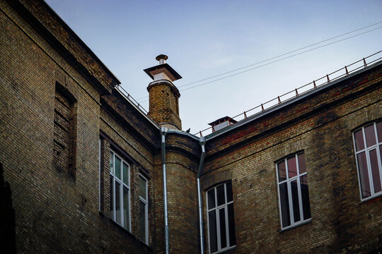 Magnificent building brick wall inner corner with plastic windows and chimney on roof with pigeon