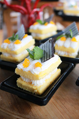 Slice of delicious vanilla cake on wooden table.
