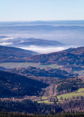 Morning mist in a valley rolling over the hills - vertical.