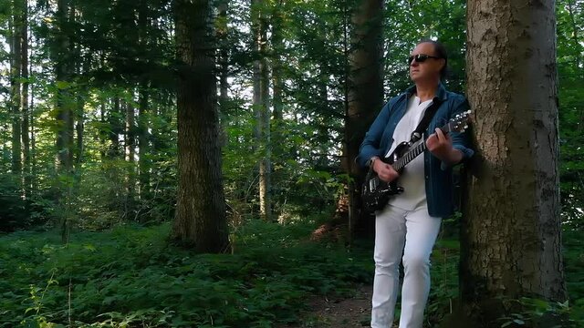 musician Playing guitar in the woods