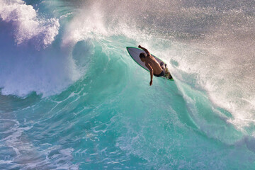 Hard charging silhouetted surfer on a gorgeous aqumarine wave on Maui. - obrazy, fototapety, plakaty