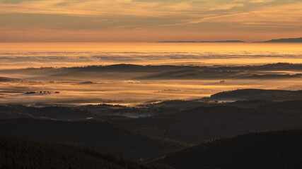 Inversion in the valley during sunrise with mountain ridge in the background.