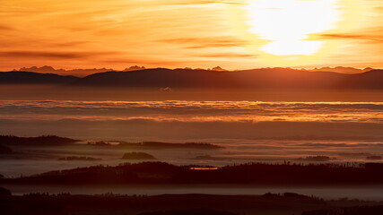 Inversion in the valley during sunrise with mountain ridge in the background.