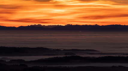 Fototapeta na wymiar Inversion in the valley during sunrise with mountain ridge in the background.