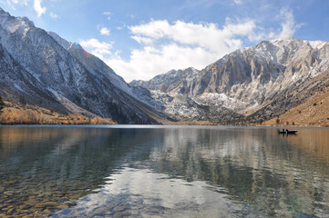 Pretty fall colors, snow-capped mountains, a fishing boat,  and reflections at Convict Lake on a cloudy day