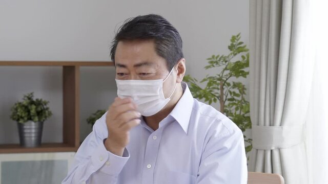 リビングで咳をする中高年男性
