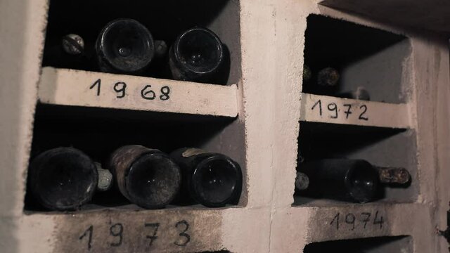 Old Expensive Bottles of Quality Red Wine Left to Age in Dark Basement Cellar