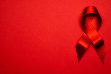 Infection symbol. Red ribbon symbol in hiv world day on dark red background. Awareness aids and cancer. Healthcare and medical concept.