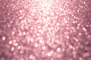 Defocused abstract pink gold twinkle light background.  Pink glittery bright shimmering background use as a design backdrop.