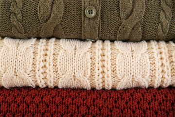 Fototapeta na wymiar Stack of warm winter clothes as background