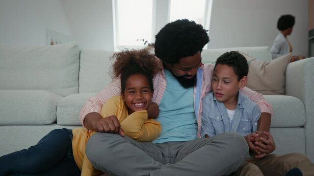 Afro father and children having fun and smiling while spending weekend at home
