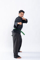 Fototapeta na wymiar young asian man in pencak silat uniform with side stance with both hands clenched in an isolated background