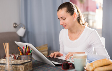 Smiling girl sitting at table at home calculating domestic finances and bills. High quality photo