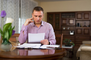 Portrait of man filling out financial documents at home