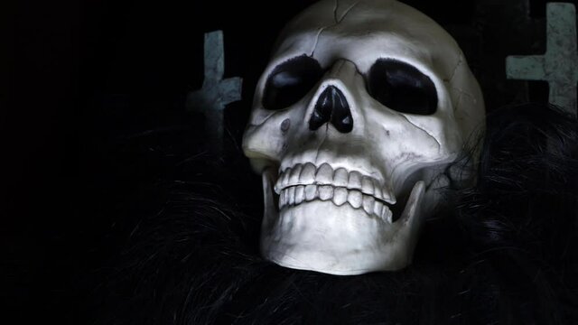 Skull with crosses on dark background zoom out shot