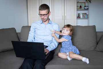 
The family is in quarantine, at home. Dad works online and a small child plays nearby