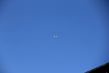 Fototapeta na wymiar 雲一つない青空を飛ぶ飛行機