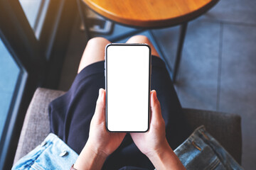 Top view mockup image of a woman holding mobile phone with blank white desktop screen