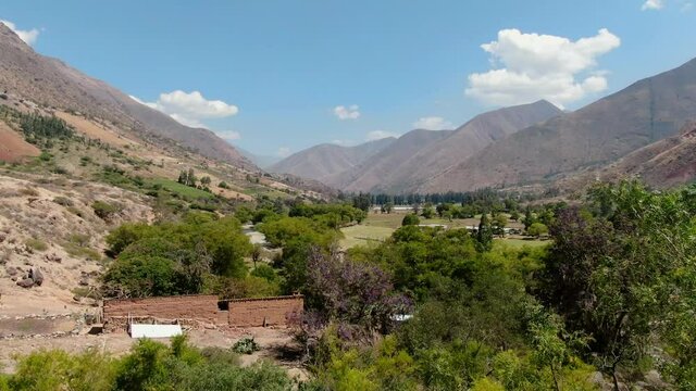 4k daytime aerial drone footage from Kotosh archeological site of Huanuco in Peru revealing the wide valley of the Higueras river. Boom/jib up wide angle shot.