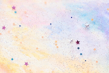 Glittery star confetti on colorful abstract pastel watercolor background