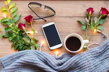 mobile phone ,hot coffee ,sunglasses and knitting wool scarf of lifestyle woman relax in winter...