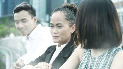 Three asian young friends standing outdoor in the city talking, smiling  and enjoying city life