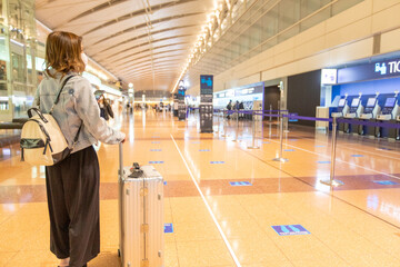 Go to トラベルでマスク姿で空港にいるアジアの若い女性