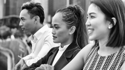Obraz premium Three asian young friends standing outdoor in the city talking, smiling and enjoying city life