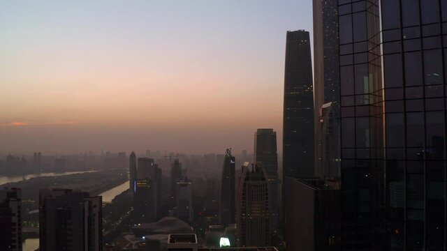 View on Guangzhou cityscape with downtown office buildings area and  city living block far in the distance on a beautiful colorful sunset. Aerial shot.