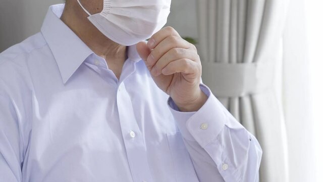 リビングで咳をする中高年男性