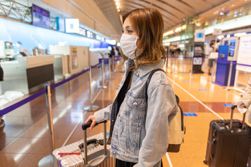 Go to トラベル　空港スーツケースで預け入れをするアジアの若い女性