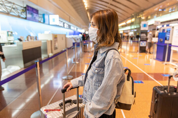Go to トラベル　空港スーツケースで預け入れをするアジアの若い女性