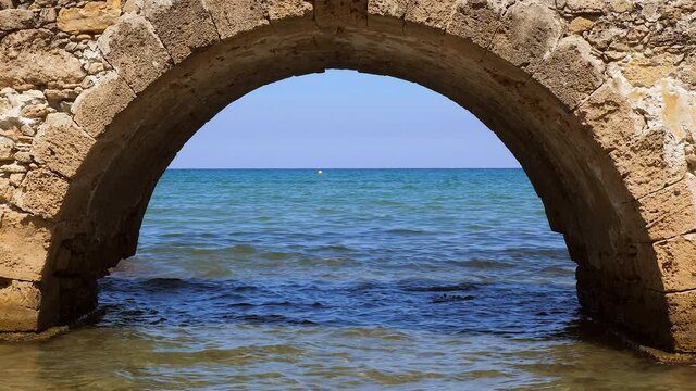 Looking through on Arch of the old Venetian Bridge Argassi on Greek Beach