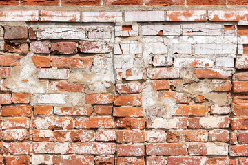 Rusty weathered red brick wall with concrete and broken parts. Old construction or weathered building. Loft or urban style of interior, background with copy space for text. Texture or effect