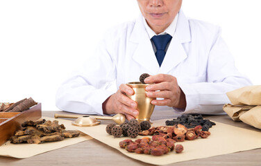 Chinese herbalist is putting herbs in the mortar