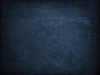 Dark blue grunge background. Texture of a plastered concrete wall. Black abstract background. Navy blue grainy rough surface texture.