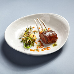 Rack of lamb in white deep plate close-up