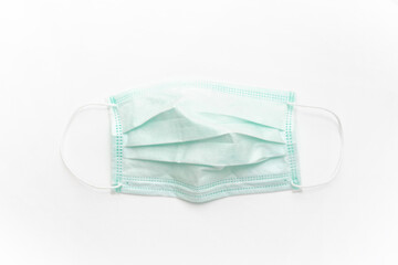 Surgical mask with rubber ear straps isolated on white background. White mask to cover the mouth and nose.