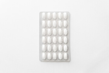 White pills tablets in package on a white background. Capsule pills in plastic pack for pharmacy and medicine.