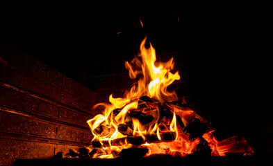 Obraz premium Hot fireplace full of wood. Real Flames from burning logs texture background. Fireplace background. Fire flame close up...