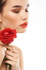 Beautiful woman with red rose near face makeup naked shoulders portrait